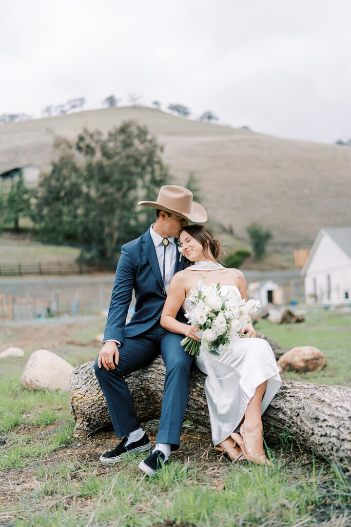 Newlywed couple sharing a tender moment outdoors on their wedding day.