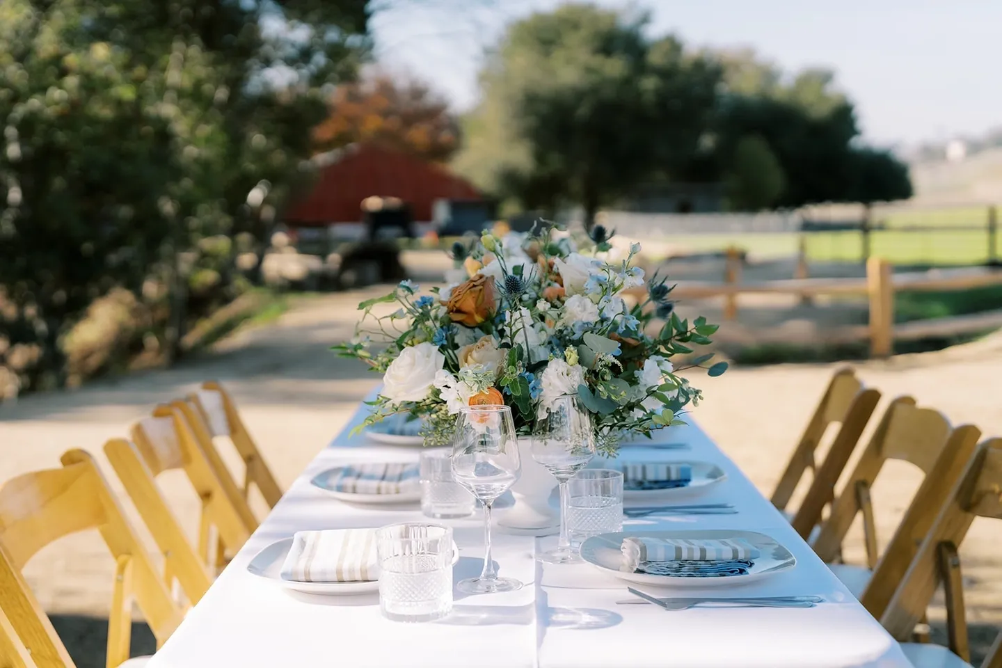 Elegant outdoor table setting with floral centerpiece and glassware.
