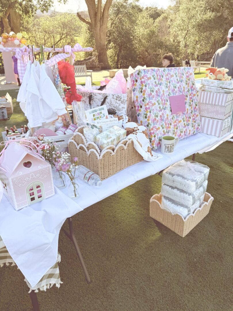 Outdoor table with decorated gingerbread houses and gifts in festive wrapping.