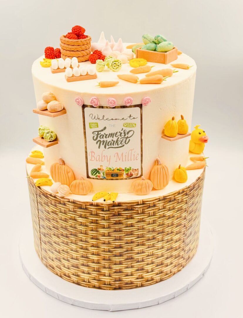Elegant two-tier cake with autumn-themed decorations and a woven basket design base.